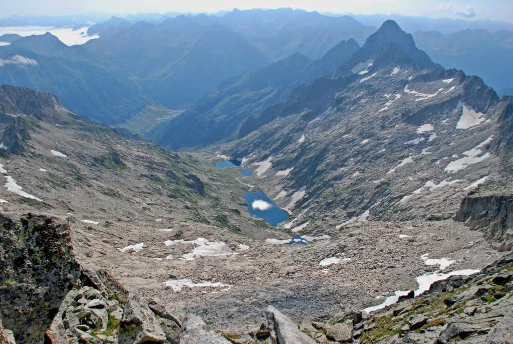 El Valle de Mulleres, una de las cabeceras del Glaciar de la Noguera Ribagorzana que alcanzó una longitud de 27 Km. A la derecha el Pico Feixant de 2.955 m, donde en 1990 se extinguió el último aparato glaciar de Cataluña. Al fondo el Macizo de Besiberri, y en el valle a la izquierda, la boca sur del Túnel de Viella. (Jordi Camins – 2009).