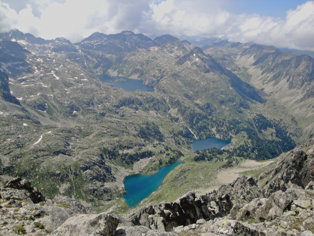 En el extremo superior izquierdo la cumbre del Besiberri Norte (3.015 m) y su cuenca glaciar, donde en la Brecha Peyta se extinguió uno de los últimos restos residuales de Cataluña. Durante la última glaciación, el glaciar orientado al norte, que ocupó los actuales sectores de los Estanys de Mar y Restanca (centro superior e inferior en la foto), extendió su lengua por el Valle de Arties, y tras un recorrido de 11 km alimentó al Glaciar de la Garona, el mayor de los Pirineos. (Jordi Camins – 2014).